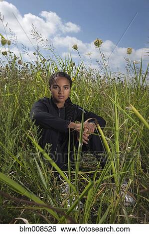 Mixed race woman sitting in grass View Large Photo Image Stock Photograph - Mixed race woman sitting in grass. Fotosearch
