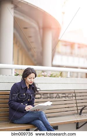 Mixed race woman sitting on bench reading View Large Photo Image Stock Photography - Mixed race woman sitting on bench reading. Fotosearch