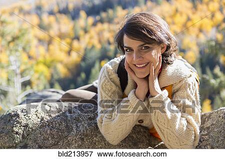 Mixed race woman smiling on rock View Large Photo Image Stock Photo - Mixed race woman smiling on rock. Fotosearch