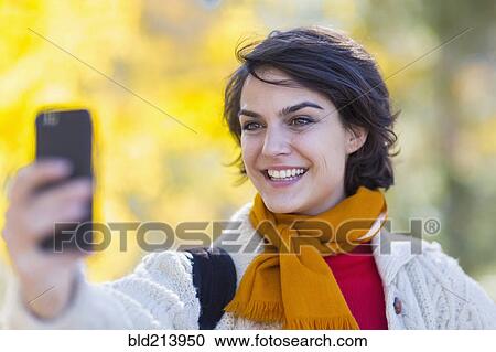 Mixed race woman taking cell phone selfie outdoors View Large Photo Image Stock Image - Mixed race woman taking cell phone selfie outdoors. Fotosearch