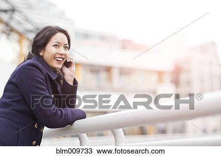 Mixed race woman talking on cell phone View Large Photo Image Stock Image - Mixed race woman talking on cell phone. Fotosearch