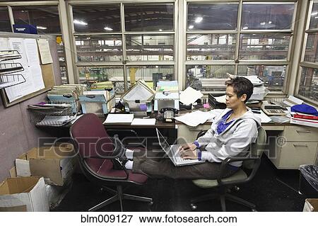 Mixed race woman using laptop in factory office View Large Photo Image Stock Photo - Mixed race woman using laptop in factory office. Fotosearch