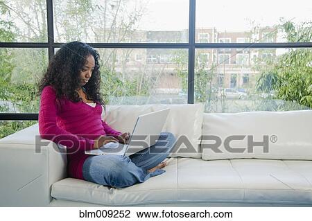 Mixed race woman using laptop on sofa View Large Photo Image Stock Image - Mixed race woman using laptop on sofa. Fotosearch