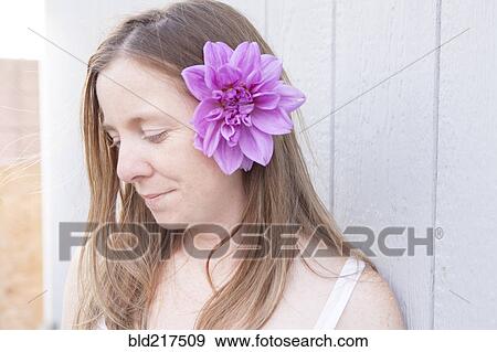 Stock Photo - Mixed race woman wearing flower in her hair. Fotosearch