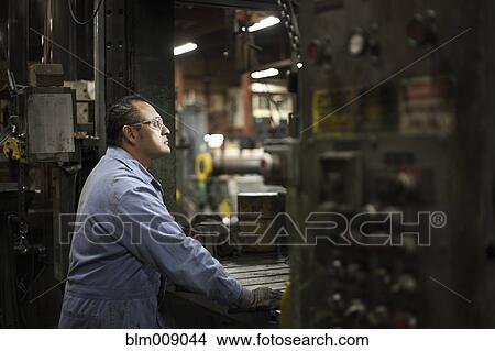 Picture - Mixed race worker working in factory. Fotosearch