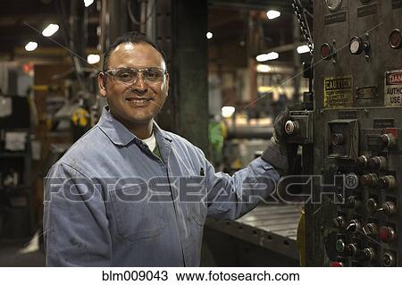 Stock Image - Mixed race worker working in factory. Fotosearch