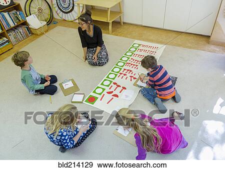 Stock Photo - Montessori teacher and students working in classroom. Fotosearch