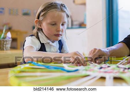 Montessori teacher helping student in classroom View Large Photo Image Stock Photograph - Montessori teacher helping student in classroom. Fotosearch