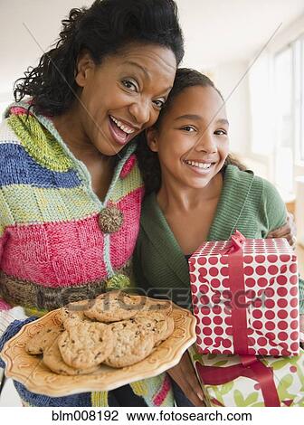 Mother and daughter carrying birthday gift and cookies View Large Photo Image Stock Image - Mother and daughter carrying birthday gift and cookies. Fotosearch