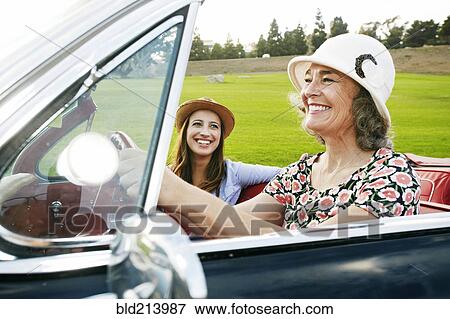 Stock Photo - Mother and daughter driving in classic convertible. Fotosearch