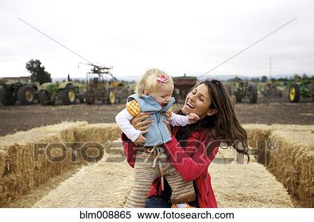 Mother and daughter enjoying playing on hay bales View Large Photo Image Stock Photography - Mother and daughter enjoying playing on hay bales. Fotosearch