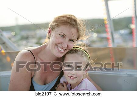 Stock Image - Mother and daughter hugging outdoors. Fotosearch