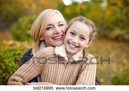 Stock Photography - Mother and daughter hugging outdoors. Fotosearch