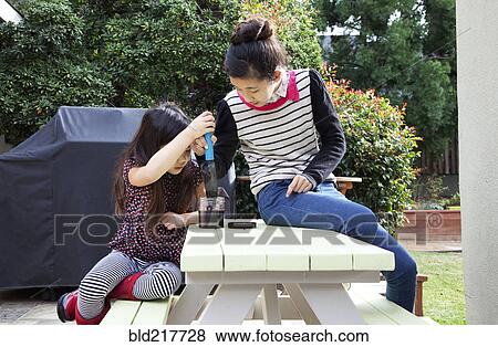 Stock Photo - Mother and daughter playing in backyard. Fotosearch