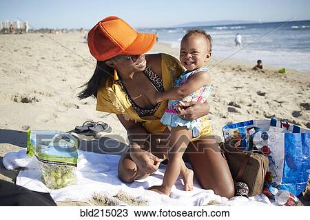 Stock Image - Mother and daughter playing on beach. Fotosearch