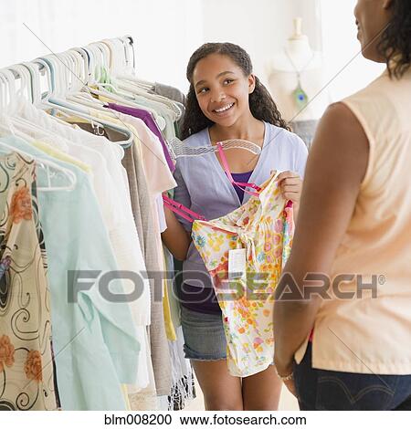 Stock Image - Mother and daughter shopping for clothing together. Fotosearch