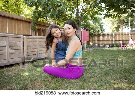Stock Photo - Mother and daughter smiling in backyard. Fotosearch