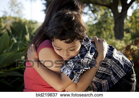 Stock Photo - Mother and son hugging outdoors. Fotosearch