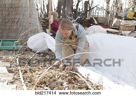 Picture - Mother and son working in autumn garden. Fotosearch