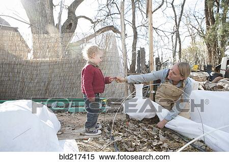 Stock Photography - Mother and son working in autumn garden. Fotosearch
