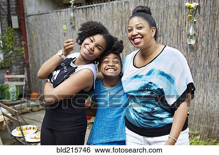 Stock Photograph - Mother, daughter and aunt relaxing in backyard. Fotosearch