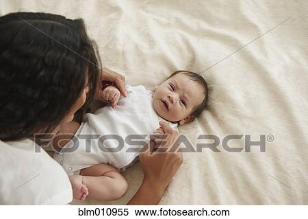 Mother laying in bed looking at baby girl View Large Photo Image Stock Photography - Mother laying in bed looking at baby girl. Fotosearch