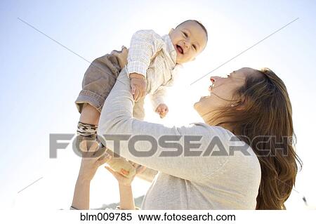Mother lifting baby outdoors View Large Photo Image Stock Photography - Mother lifting baby outdoors. Fotosearch