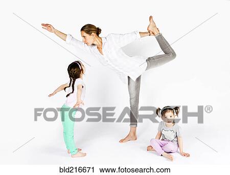 Mother practicing yoga with playful daughters View Large Photo Image Stock Image - Mother practicing yoga with playful daughters. Fotosearch