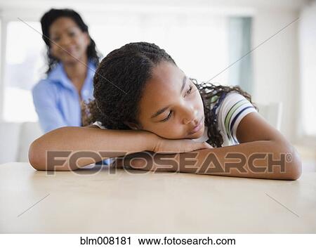 Stock Image - Mother watching sad daughter. Fotosearch
