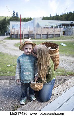 Mother with long hair kissing son in park View Large Photo Image Stock Photograph - Mother with long hair kissing son in park. Fotosearch