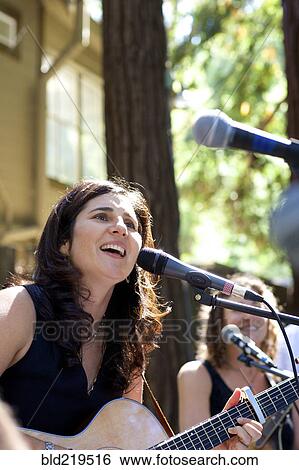 Stock Photograph - Musicians performing on stage outdoors. Fotosearch