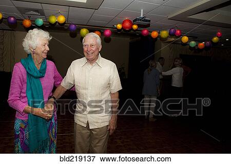 Stock Photo - Older Caucasian couple dancing at party in retirement home. Fotosearch