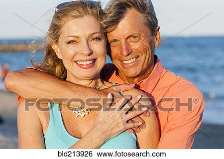 Older Caucasian couple hugging on beach View Large Photo Image Stock Photograph - Older Caucasian couple hugging on beach. Fotosearch