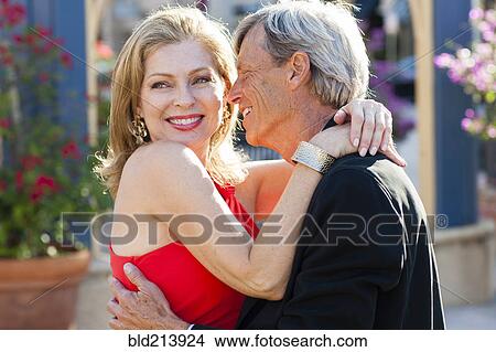 Picture - Older Caucasian couple hugging outdoors. Fotosearch
