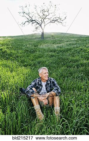 Older Caucasian man sitting on grassy hillside View Large Photo Image Stock Photo - Older Caucasian man sitting on grassy hillside. Fotosearch