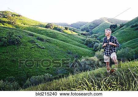 Older Caucasian man smiling on grassy hillside View Large Photo Image Stock Image - Older Caucasian man smiling on grassy hillside. Fotosearch