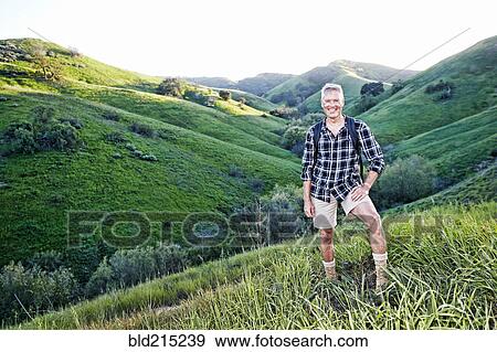 Stock Photo - Older Caucasian man smiling on grassy hillside. Fotosearch