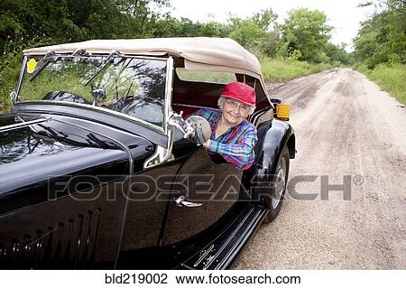 Older Caucasian woman driving convertible on rural road View Large Photo Image Stock Image - Older Caucasian woman driving convertible on rural road. Fotosearch