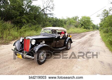 Older Caucasian woman driving convertible on rural road View Large Photo Image Stock Image - Older Caucasian woman driving convertible on rural road. Fotosearch