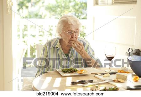 Picture - Older Caucasian woman eating lunch at table. Fotosearch