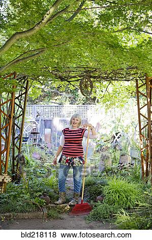 Stock Photo - Older Caucasian woman gardening in backyard. Fotosearch
