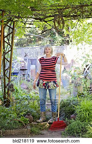 Stock Photo - Older Caucasian woman gardening in backyard. Fotosearch
