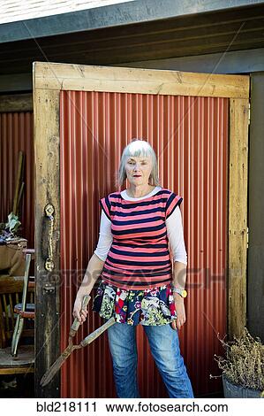 Older Caucasian woman holding shears in backyard View Large Photo Image Stock Image - Older Caucasian woman holding shears in backyard. Fotosearch