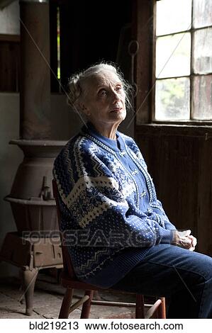 Stock Image - Older Caucasian woman sitting in chair. Fotosearch
