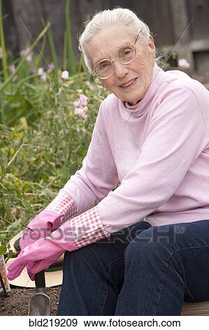 Older Caucasian woman sitting in garden View Large Photo Image Stock Photo - Older Caucasian woman sitting in garden. Fotosearch