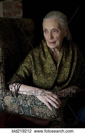 Stock Image - Older Caucasian woman sitting in armchair. Fotosearch