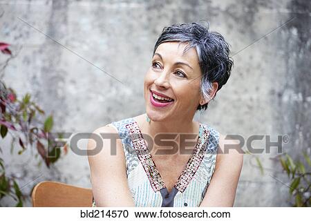 Stock Image - Older Caucasian woman sitting outdoors. Fotosearch