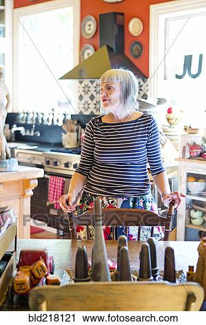 Older Caucasian woman standing at table in kitchen View Large Photo Image Stock Image - Older Caucasian woman standing at table in kitchen. Fotosearch