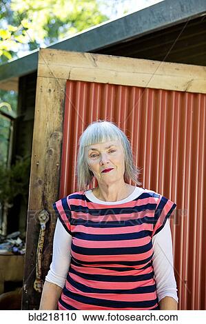 Older Caucasian woman standing in backyard View Large Photo Image Stock Image - Older Caucasian woman standing in backyard. Fotosearch