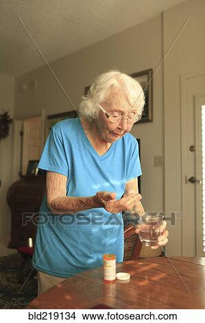 Picture - Older Caucasian woman taking medication. Fotosearch